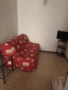 a red couch sitting in the corner of a room at Duplex meublé Mercantour in Fontan