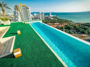a swimming pool with a view of the ocean at the andromeda condominium seaview in Pattaya South