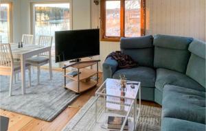 a living room with a blue couch and a table at Stunning Home In Rtviken With Kitchen 