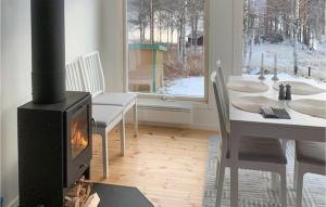 a living room with a stove and a table with a fireplace at Stunning Home In Rtviken With Kitchen 