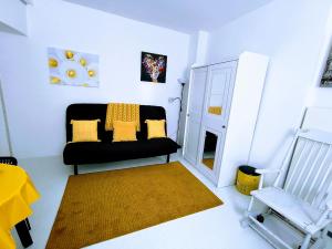 un soggiorno con divano nero e sedia di Ca' Sistina Yellow a Morcote
