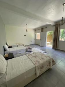 a large bedroom with two beds and a window at Maison d H&ocirc;te Ighrem in Goulmima