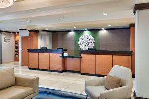 a lobby with a waiting room with two chairs and a counter at Fairfield Inn & Suites by Marriott Tallahassee Central in Tallahassee