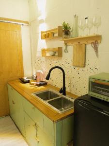 a kitchen counter with a sink and a microwave at Migo Housing 1 - Beer Street - Old Quarter in Hanoi