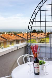 リッチョーネにあるWe Home - CASOLI View 11 Riccioneのワイングラス付きのテーブルに座ったワイン1本