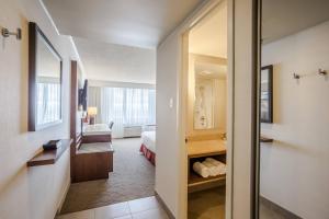 a hotel room with a bathroom and a bedroom at Delta Hotels by Marriott Saguenay Conference Centre in Saguenay
