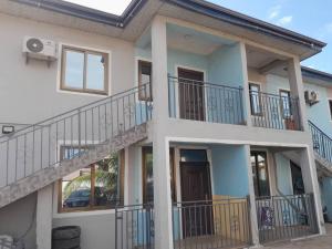 ein Haus mit Balkon an der Seite in der Unterkunft Private Executive Apartments in Accra