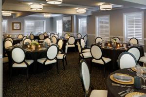 a set of tables and chairs in a room at Ambassador Hotel Tulsa, Autograph Collection in Tulsa