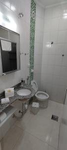 bagno con lavandino, servizi igienici e specchio di Flat Cavalinho Branco - 50J ad Águas de Lindóia
