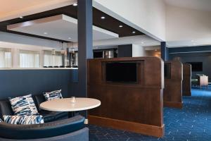 a waiting room with a tv and a table and chairs at Courtyard by Marriott San Antonio Airport in San Antonio
