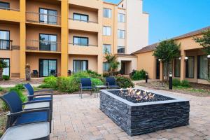 un patio con sillas y una hoguera frente a un edificio en Courtyard by Marriott San Antonio Airport, en San Antonio