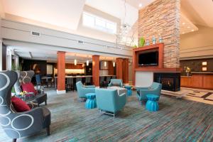 a lobby with blue chairs and a fireplace at Residence Inn Toledo Maumee in Maumee