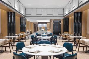 a dining room with tables and chairs at Fairfield by Marriott Shanghai Jingan in Shanghai