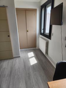 an empty living room with a television and a door at Chambre privée indépendante in Chenac-sur-Gironde