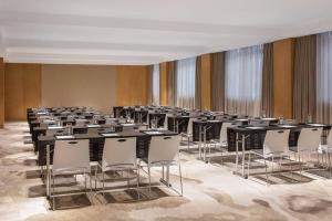 Cette chambre comprend des rangées de tables et de chaises blanches. dans l'établissement Fairfield by Marriott Shanghai Jingan, à Shanghai