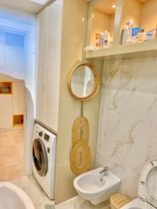 a bathroom with a washing machine and a sink at Beach Garden Paradise in Durrës