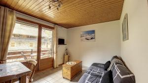 a bedroom with a bed and a table and a window at Schuss 6 appartement 4 pax au pied des pistes in Saint-Jean-d'Aulps