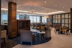 a restaurant with tables and chairs and a flat screen tv at TownePlace Suites by Marriott Saskatoon in Saskatoon