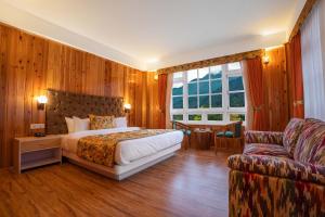 - une chambre avec un lit et un canapé dans l'établissement Summit Gangchen Hotel, à Lachen