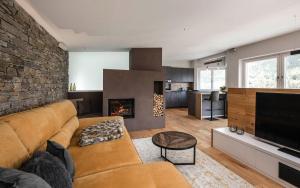 a living room with a couch and a fireplace at Dolomites Alpin Penthouse, 90qm, WLAN, privat Sauna - privat Whirlpool in Mühlbach