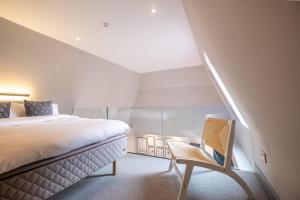 a bedroom with a bed and a chair in a room at The Arran, St Andrews in St. Andrews
