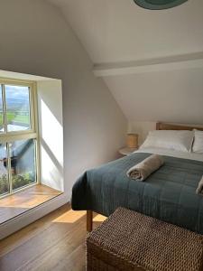 a bedroom with a bed and a large window at Murphy's Mountain Cottage in Clonmel