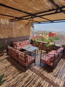 eine Terrasse mit zwei Sofas und einem Tisch auf dem Dach in der Unterkunft la sublime in Taghazout