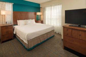 a bedroom with a bed and a flat screen tv at Residence Inn by Marriott Portland North in Portland