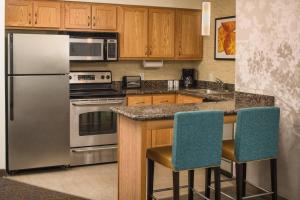 una cocina con electrodomésticos de acero inoxidable y armarios de madera en Residence Inn by Marriott Portland North, en Portland