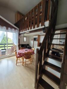 a kitchen and dining room with a table and a staircase at LE CHALET, Superbe Duplex avec Balcon aux Rousses, Netflix, WI-FI, Parking Gratuit et Draps inclus - Animaux Interdits in Les Rousses