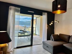 salon z kanapą i balkonem w obiekcie BEL'ORIZONTE B , proche centre ville et plage w mieście Propriano