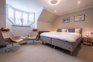 a bedroom with a bed and two chairs at The Arran, St Andrews in St. Andrews