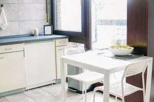Una cocina blanca con una mesa y sillas blancas. en Nespresso Netflix Work Appartment - 24h Check-In, en Bielefeld
