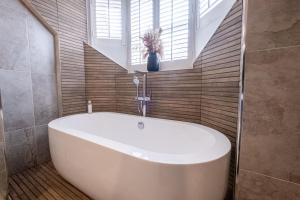 a white bath tub in a bathroom with a window at The Arran, St Andrews in St. Andrews