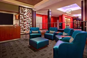 a waiting room with blue chairs and a flat screen tv at TownePlace Suites by Marriott London in London