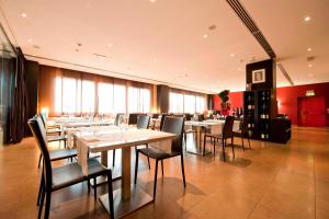 una grande sala da pranzo con tavoli e sedie di AC Hotel Padova by Marriott a Padova