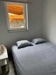 a bedroom with a bed and a window in it at Guest House Iva in Senj