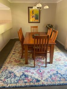 mesa de comedor y sillas en una alfombra en Tranquility in the Swan Valley en The Vines