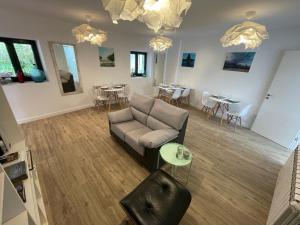 een woonkamer met een bank en tafels en stoelen bij Apartamentos turísticos Praia de Seselle, terraza y jardín a un paso de la playa in Ares