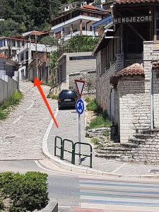 ein Auto, das eine Straße mit einem Straßenschild entlangfährt in der Unterkunft Guest House Noah&Kristel in Berat