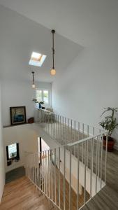 a white staircase in a house with a plant at Apartamentos turísticos Praia de Seselle, terraza y jardín a un paso de la playa in Ares