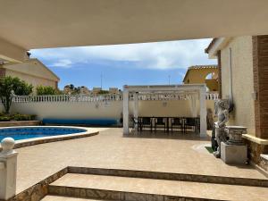 un patio con pérgola y piscina en Villas Yanina Luxe Gran Alacant, en Puerto Marino
