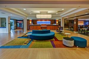 a lobby of a hotel with a blue couch andools at Fairfield Inn and Suites by Marriott Naples in Naples