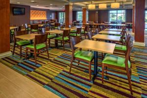 a dining room with tables and chairs on a rug at Fairfield Inn and Suites by Marriott Naples in Naples