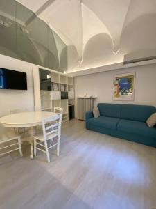 un soggiorno con divano blu e tavolo di DUOMO26 BOUTIQUE APARTMENT a Desenzano del Garda