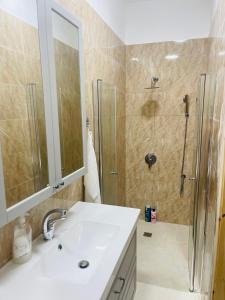 y baño con lavabo y ducha. en Nilis vila הווילה של נילי, en Mishmār Hāyardin