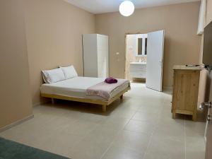 een slaapkamer met een bed in de hoek van een kamer bij Nilis vila הווילה של נילי in Mishmār Hāyardin