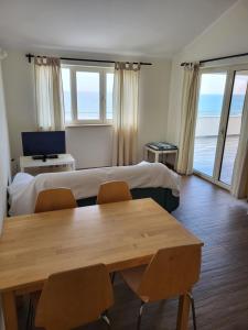 a hotel room with two beds and a table and chairs at Apartments Alen in Umag