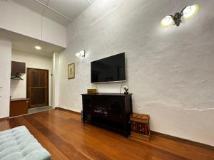 a living room with a flat screen tv on a white wall at 19th Century Boutique Hotel in Melaka