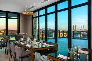 a restaurant with tables and chairs and a view of the city at AC Hotel by Marriott Portsmouth Downtown/Waterfront in Portsmouth